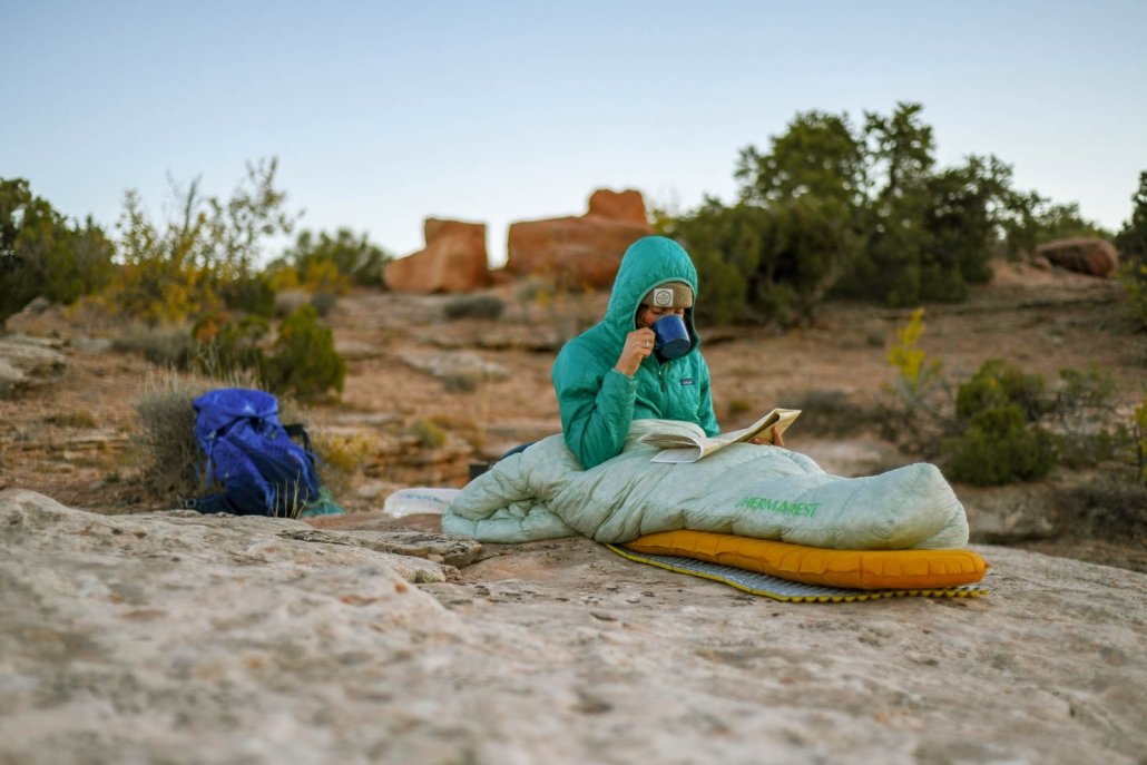 person camped out in the desert resting on a therm-a-rest sleeping pad, one of the best for backpacking