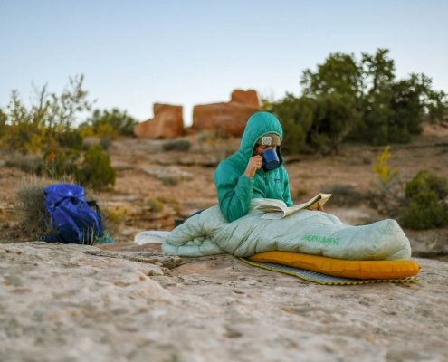 person camped out in the desert resting on a therm-a-rest sleeping pad, one of the best for backpacking