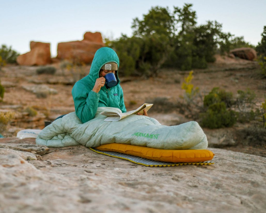 a woman uses a therm-a-rest sleeping bag or quilt in the desert