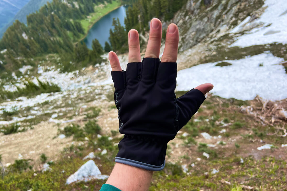hiking gloves in front of a lake