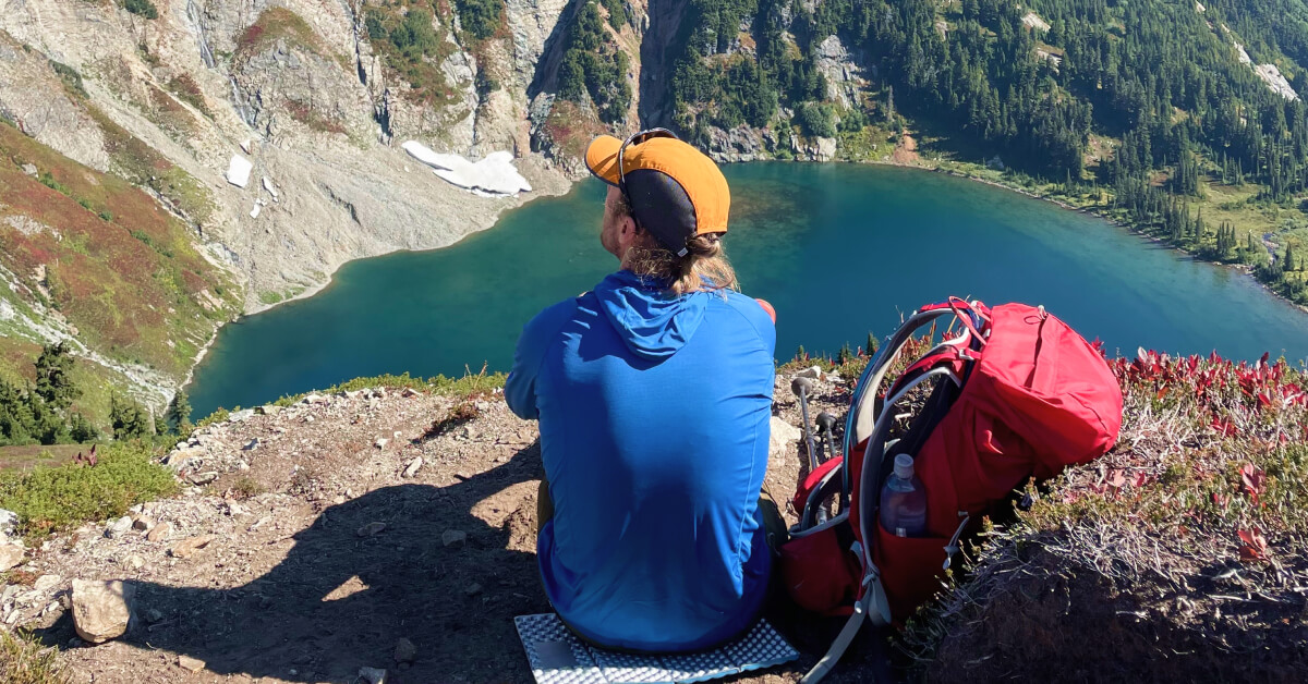 testing hiking hats above a lake in blue sun hoody