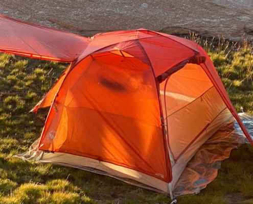 a small 2 person tent in the grass