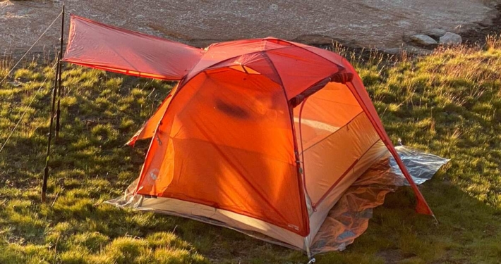 a small 2 person tent in the grass