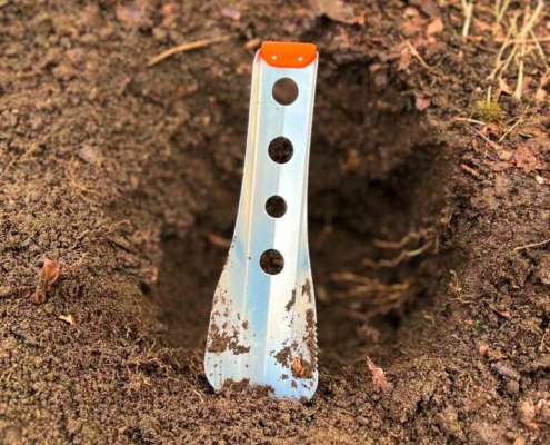 the Best Backpacking Trowel in front of a cat hole