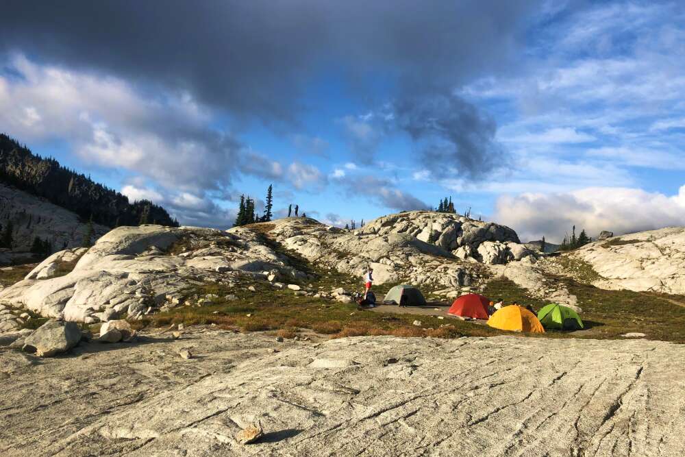 a backpacking tent on rocks with storm coming