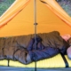 a person in a 2 person sleeping bag in a tent