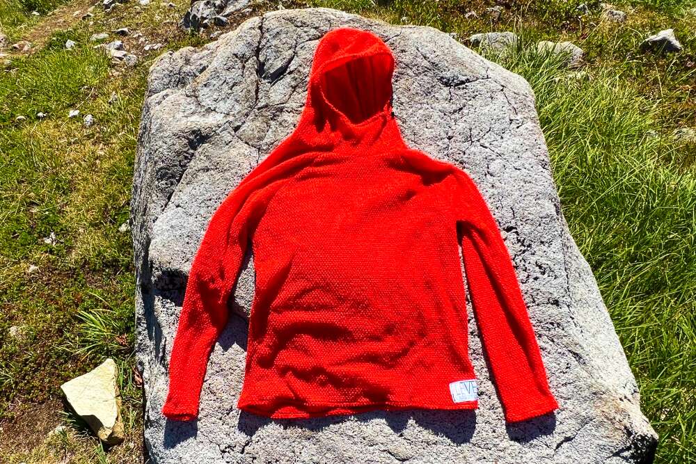 LEVE Outdoor Co Alpha Direct Hoodie in red on a rock