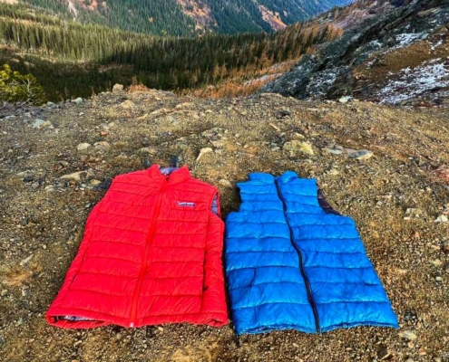 red and blue Ultralight Down Vests For Backpacking lying flat in the mountains