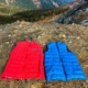 red and blue Ultralight Down Vests For Backpacking lying flat in the mountains