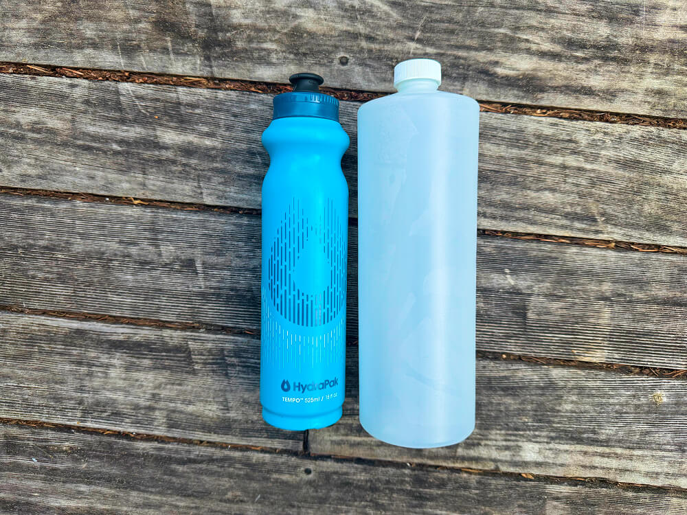two hard ultralight water bottles side by side, hydrapak tempo and ggg hdpe plastic 1l
